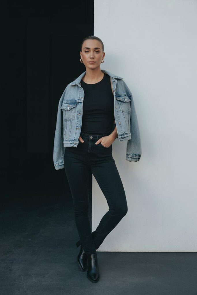 All black outfit with light denim jacket as statement piece for modern minimalist style