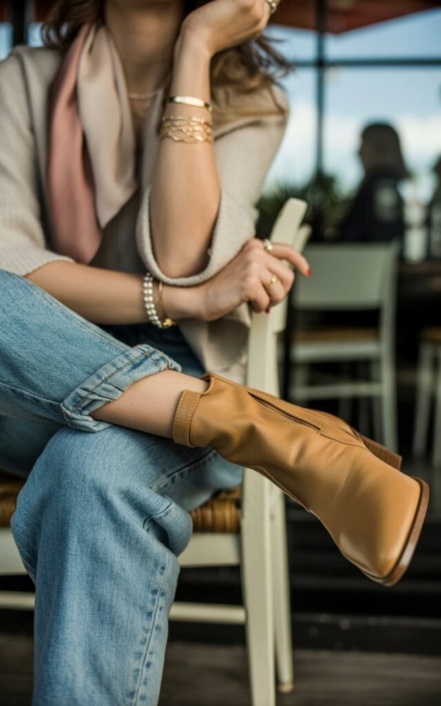 Jeans and boots accessory details with matching belt, jewelry, and handbag