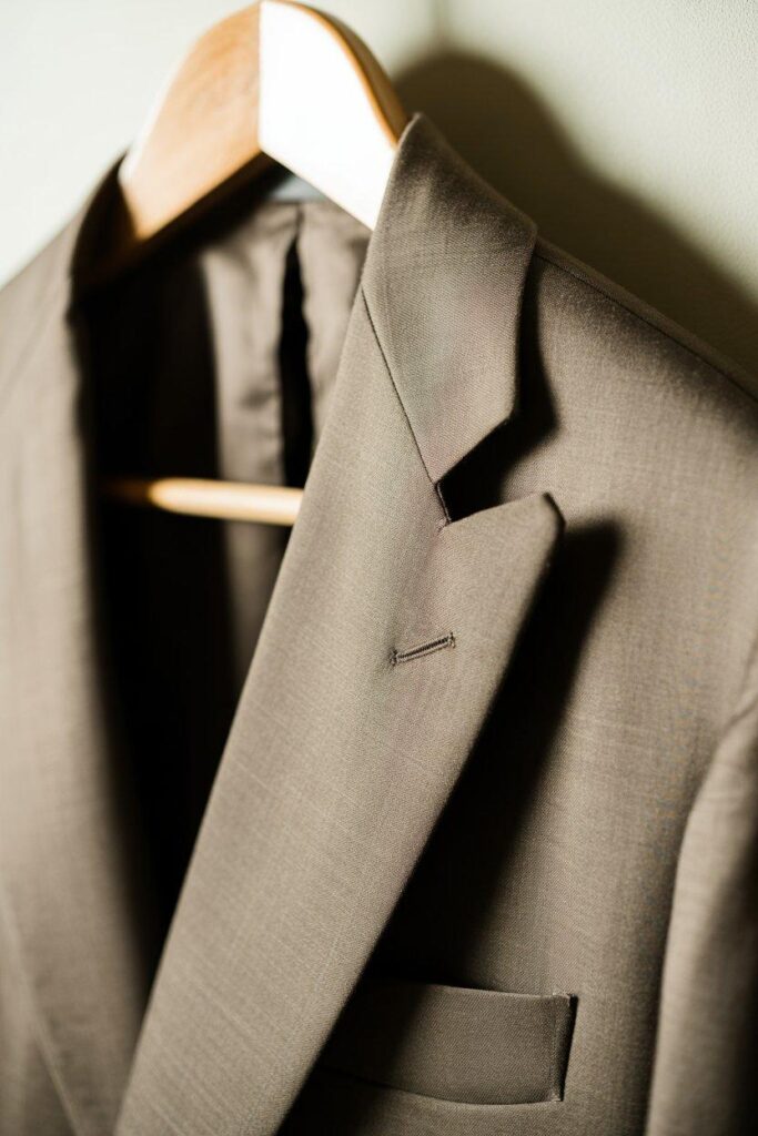 High-quality blazer with excellent tailoring and fabric texture hanging on wooden hanger