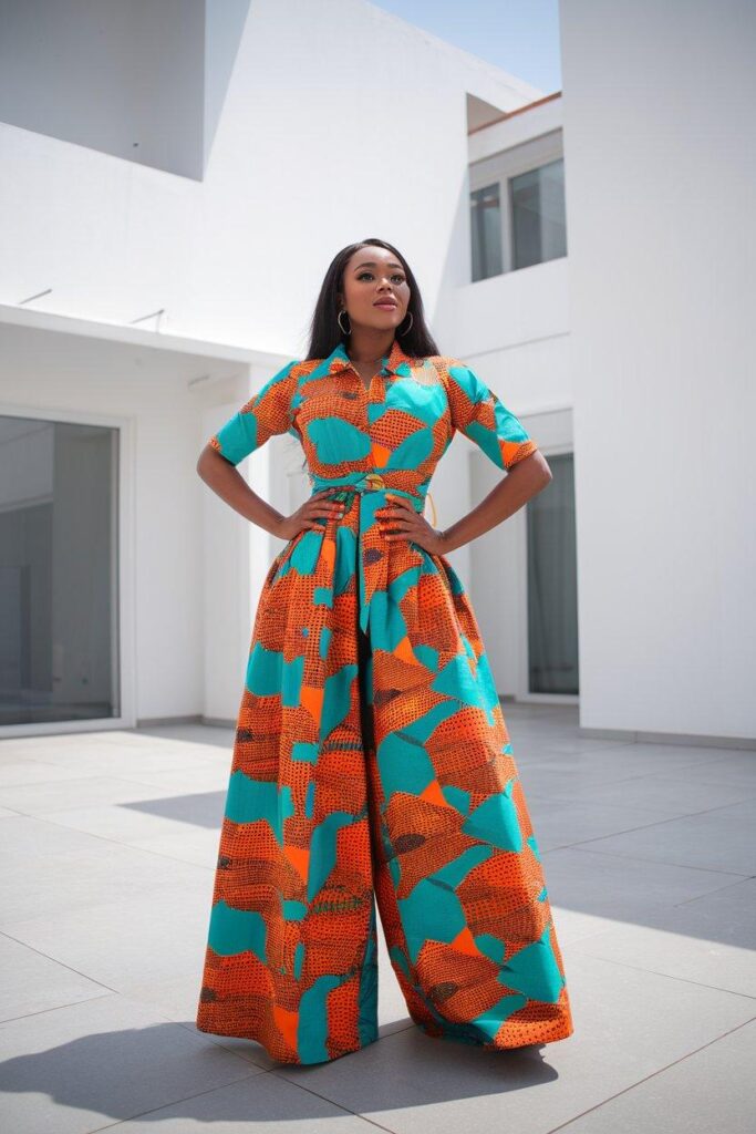African woman posing in bold Ankara jumpsuit with wide legs