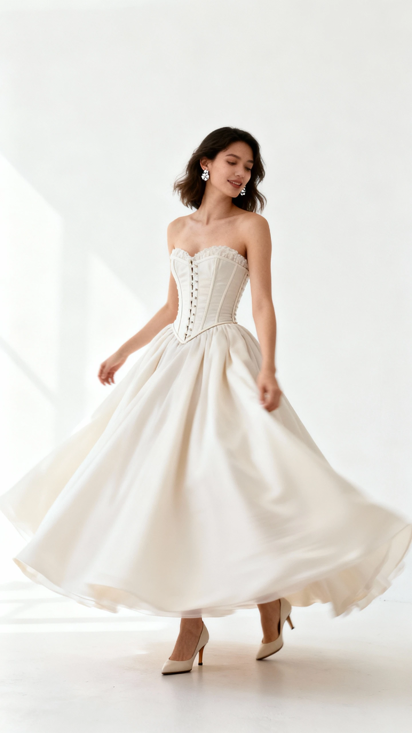 Studio fashion photo of a woman wearing a corset-bodice ball gown with a structured waist and full sweeping skirt, subtle sparkle earrings and classic pumps, white background, studio lighting, gentle twirl captured, clean composition, high quality.
